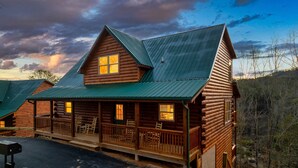 A log cabin with a porch, multiple windows, and a metal roof. - Best Location 5BR Sleeps 16 (Pigeon Forge)