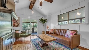 A spacious living room with a wooden coffee table, a leather sofa, and a large window. - Modern Lake House 2 Units, Pool, Lake 3Min, Pets (Somerville)