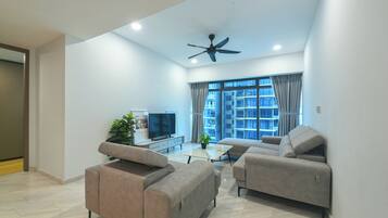 A modern living room with two sofas, a coffee table, a TV, and a ceiling fan.