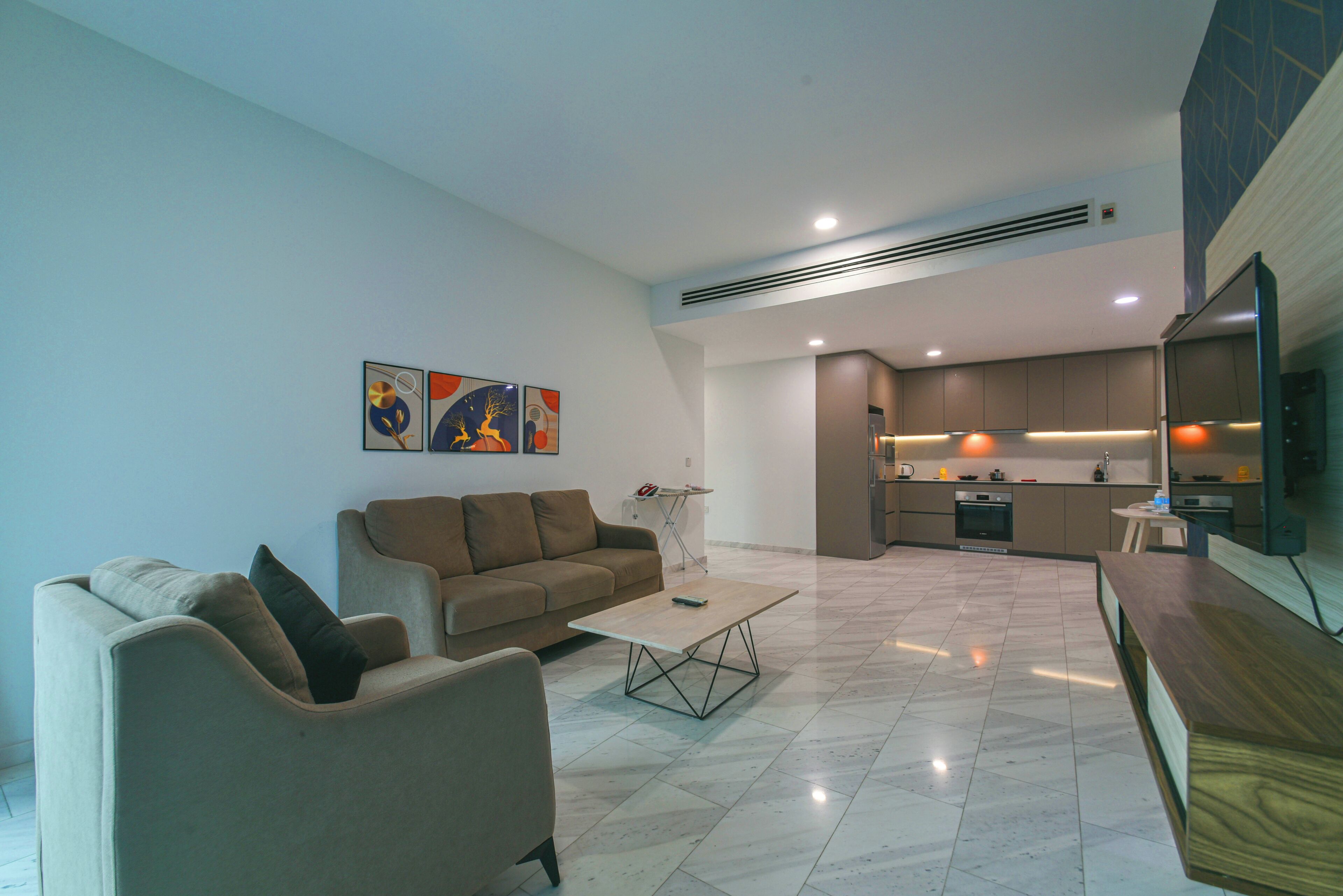 A modern living room with a sofa, coffee table, and artwork on the wall.
