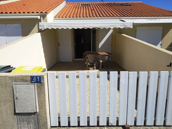 A residential building with a tiled roof, a white picket fence, and a number 41 sign.