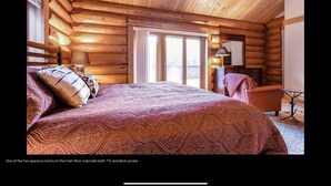 A spacious room with a bed, a TV, and a private bathroom.