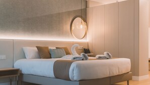A modern hotel room with a large bed, a bedside table, a lamp, and a mirror on the wall. - Hotel Candor (A Lama)