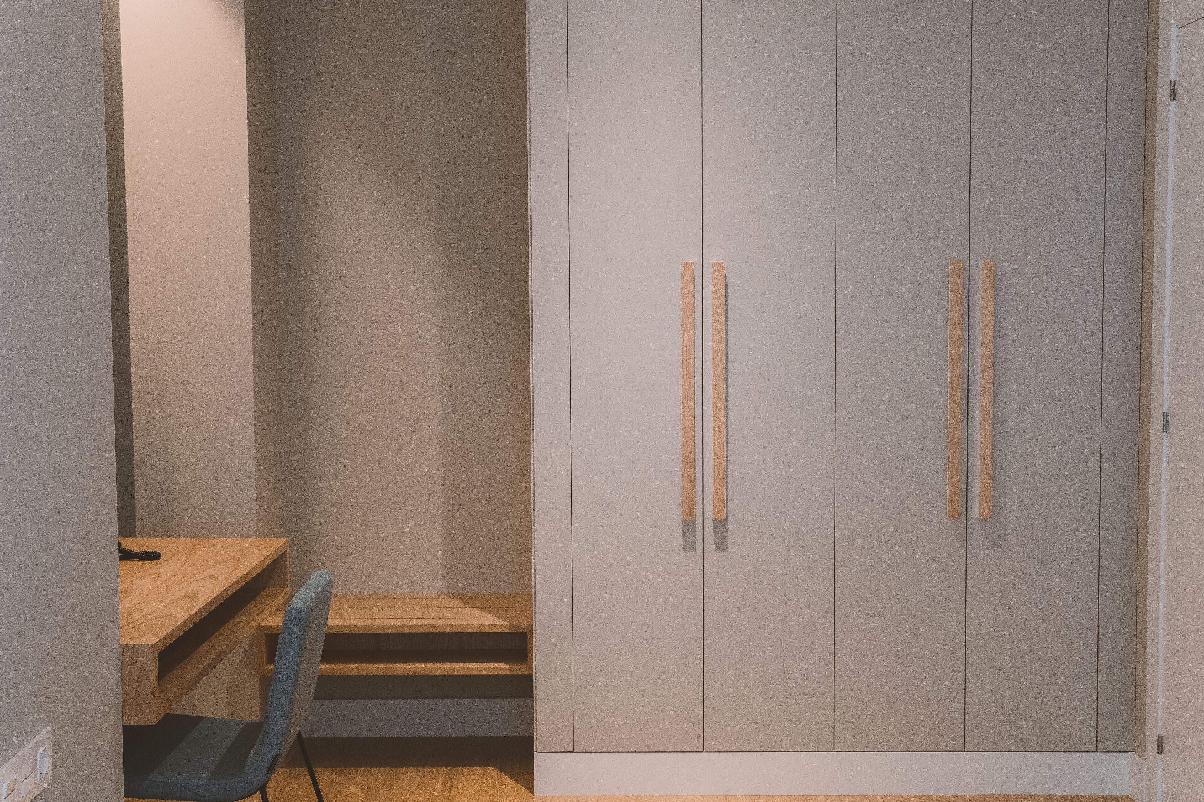 Ein Schlafzimmer mit Bett, Schreibtisch und Kleiderschrank.