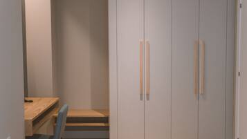 Ein Schlafzimmer mit Bett, Schreibtisch und Kleiderschrank.