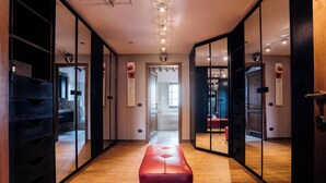 Un couloir doté d’un plancher en bois, d’un banc rouge et de murs recouverts de miroirs.