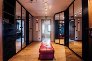 Un couloir doté d’un plancher en bois, d’un banc rouge et de murs recouverts de miroirs.