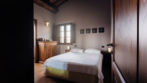 Une chambre à coucher avec un lit, une armoire en bois et une fenêtre.