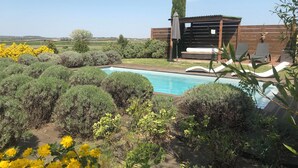 A pool surrounded by lush greenery and a wooden deck. - Air-conditioned gîte: a swimming pool just for you, superb view of the Cévennes  (Blauzac)