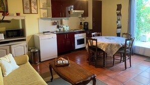 A compact kitchen with a dining area, a white dishwasher, a microwave, and a coffee maker. - Air-conditioned gîte: a swimming pool just for you, superb view of the Cévennes  (Blauzac)