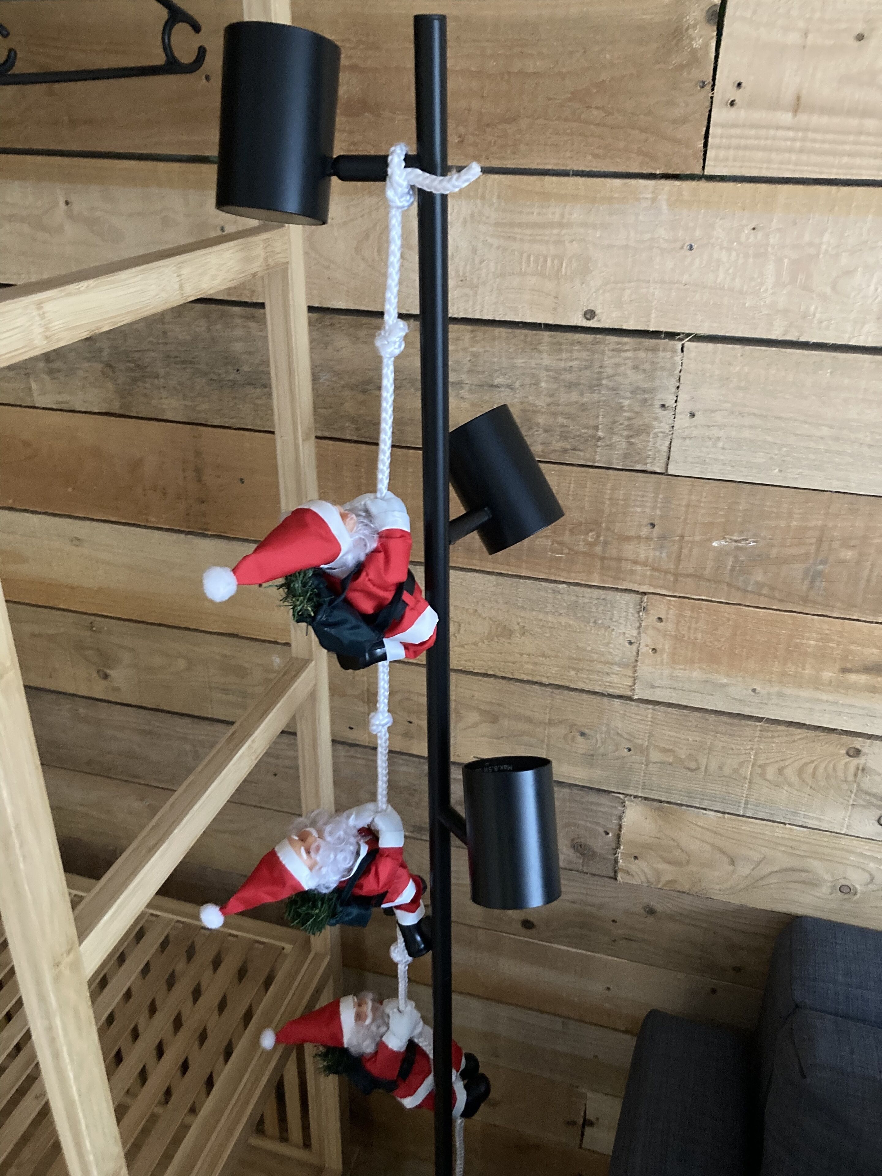 Et træinteriør med en sort metalreol, der holder tre julemanden-pynt.