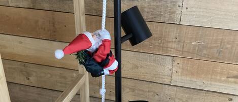 Et træinteriør med en sort metalreol, der holder tre julemanden-pynt.