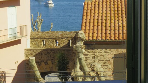 Blick auf die Küste mit einem Gebäude, das ein Ziegeldach und eine Statue hat.