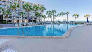A hotel with a swimming pool, palm trees, and a view of the ocean. - Oceanfront Paradise: Your Dream Beachfront Escape (Panama City Beach)