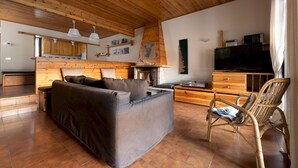 A cozy living area with a sofa, a wooden dining table, and a television. - Italianway - Capitano Grandi 5 (Bormio)
