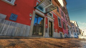 Ein rotes Gebäude mit Glastür und einer Metallmarkise.
