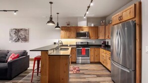 A modern kitchen with wooden cabinets, stainless steel appliances, and a central island.