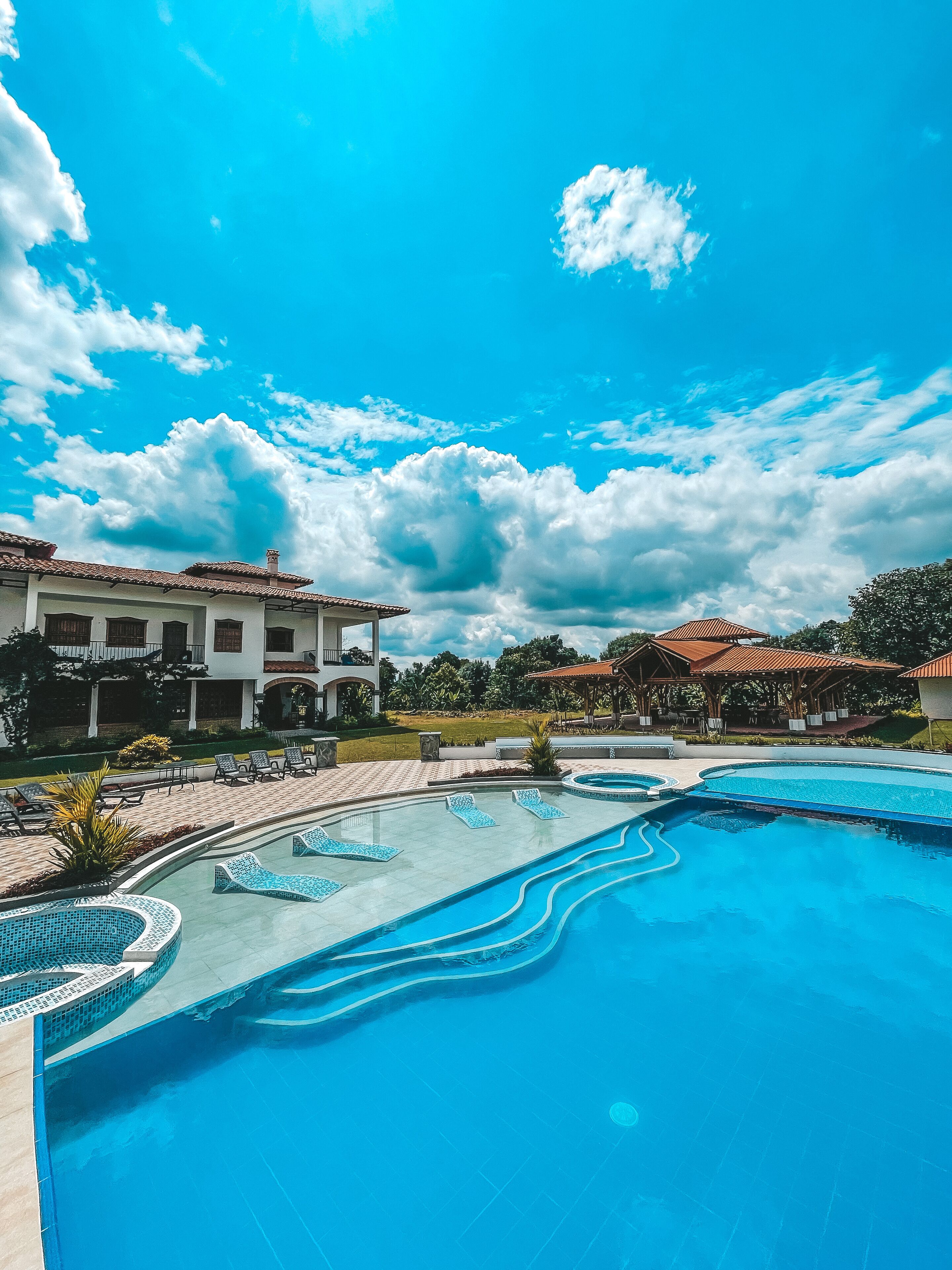 Una piscina al aire libre, camas de piscina gratis, sombrillas