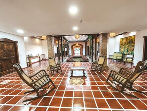 A spacious lobby with a tiled floor, a central seating area with chairs, and a large painting on the wall. - Hotel la Casona Montañesa (Montenegro)
