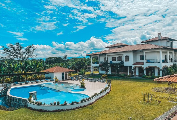 A large house with a swimming pool, surrounded by a well-maintained lawn and tropical plants. - Hotel la Casona Montañesa (Montenegro)