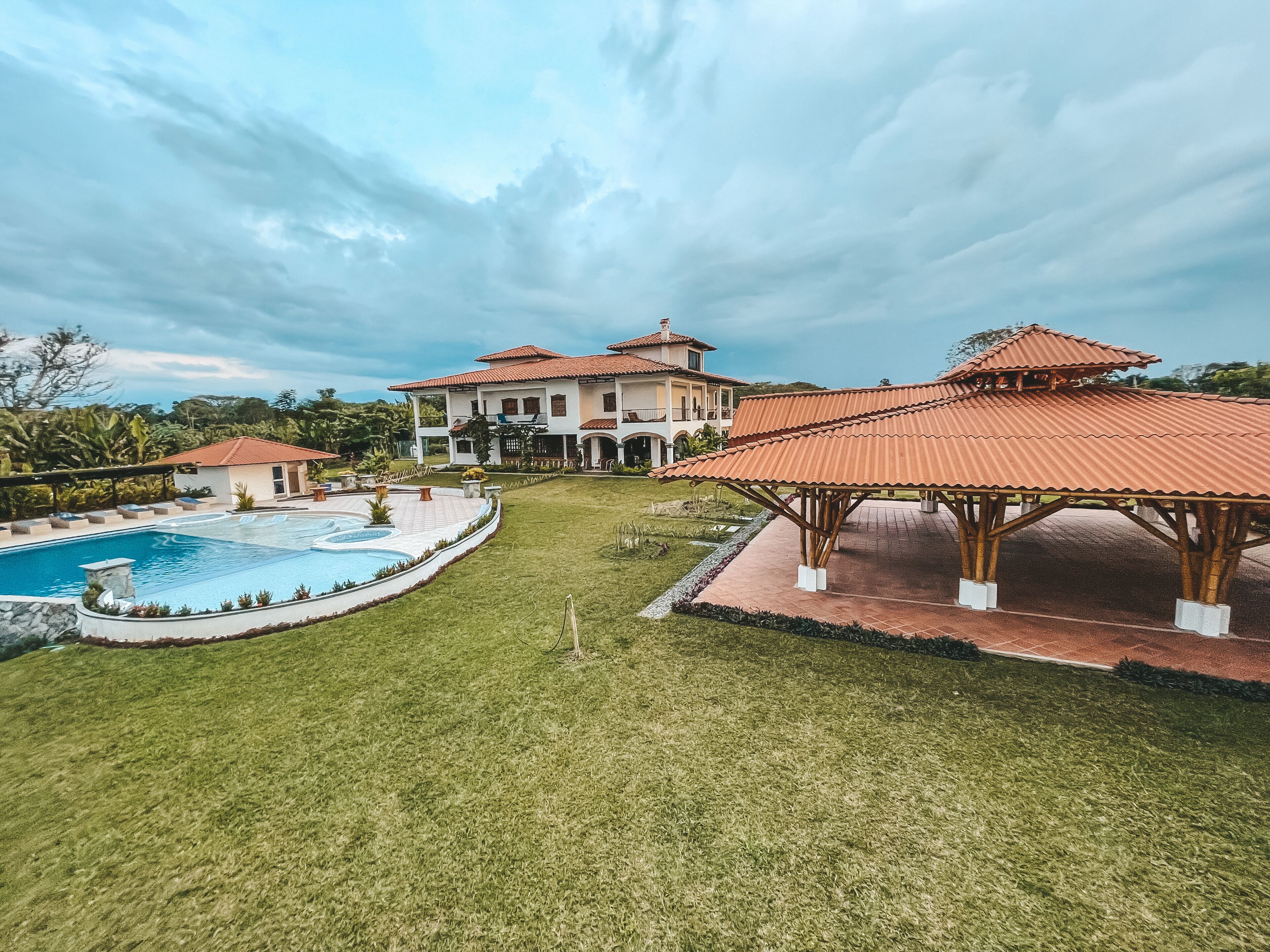 Une grande maison avec une piscine, un belvédère et une pelouse bien entretenue.