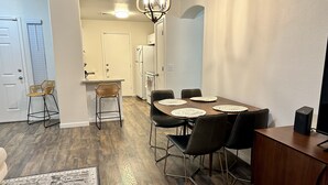 A modern kitchen with a dining area, wooden flooring, and a chandelier. - Close to everything!  2bed/2 bath (Surprise)