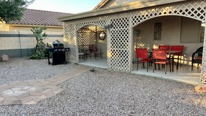 A patio area with a grill, outdoor seating, and a decorative fence. - Close to everything!  2bed/2 bath (Surprise)