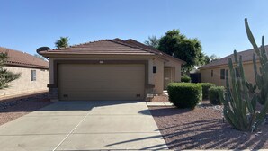 A single-story house with a garage, a driveway, and a small garden with a cactus. - Close to everything!  2bed/2 bath (Surprise)