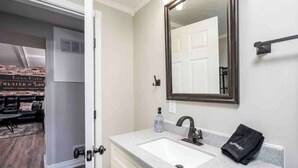 Une salle de bain avec un lavabo blanc, un miroir et une serviette.