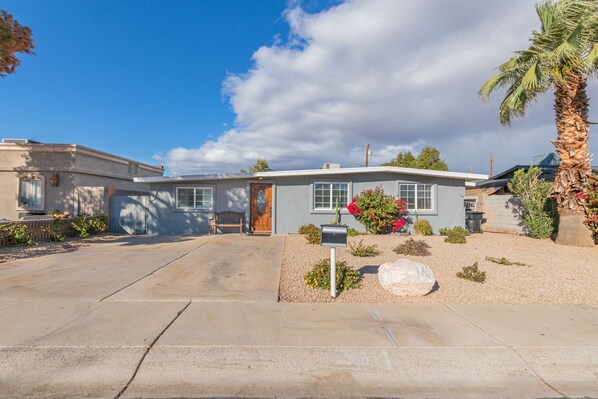 A single-story house with a front porch, a mailbox, and a small garden with flowers and a palm tree. - Spacious home. Perfect for large groups family friendly 5 bed/ 3 bath 
 (Phoenix)