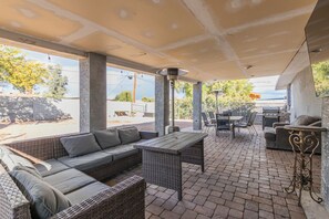 An outdoor patio area with wicker furniture, a grill, and a covered seating area. - Spacious home. Perfect for large groups family friendly 5 bed/ 3 bath 
 (Phoenix)