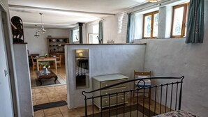 A compact room with a bed, a small table, and a chair. There is a window with curtains and a view of the outside. - Idyllic Country Location for couples, central, peaceful, 5 mins from shops, WIFI (LOPEREC)