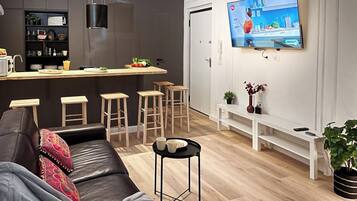 ファミリー アパートメント | リビング エリア | 55 インチの薄型テレビ (ケーブル放送視聴可)、テレビ、おもちゃ