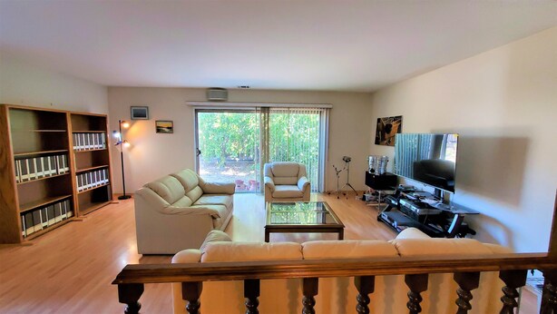A living room with a sofa, a coffee table, a TV, and a bookshelf. - Delightful Spacious 3-bedroom Home in Silicon Valley (Santa Clara)