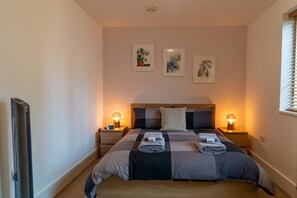 A bedroom with a bed, two bedside tables, a flat-screen TV, and wall art. - Family & Corporate Business Traveller Friendly Apartment (London)