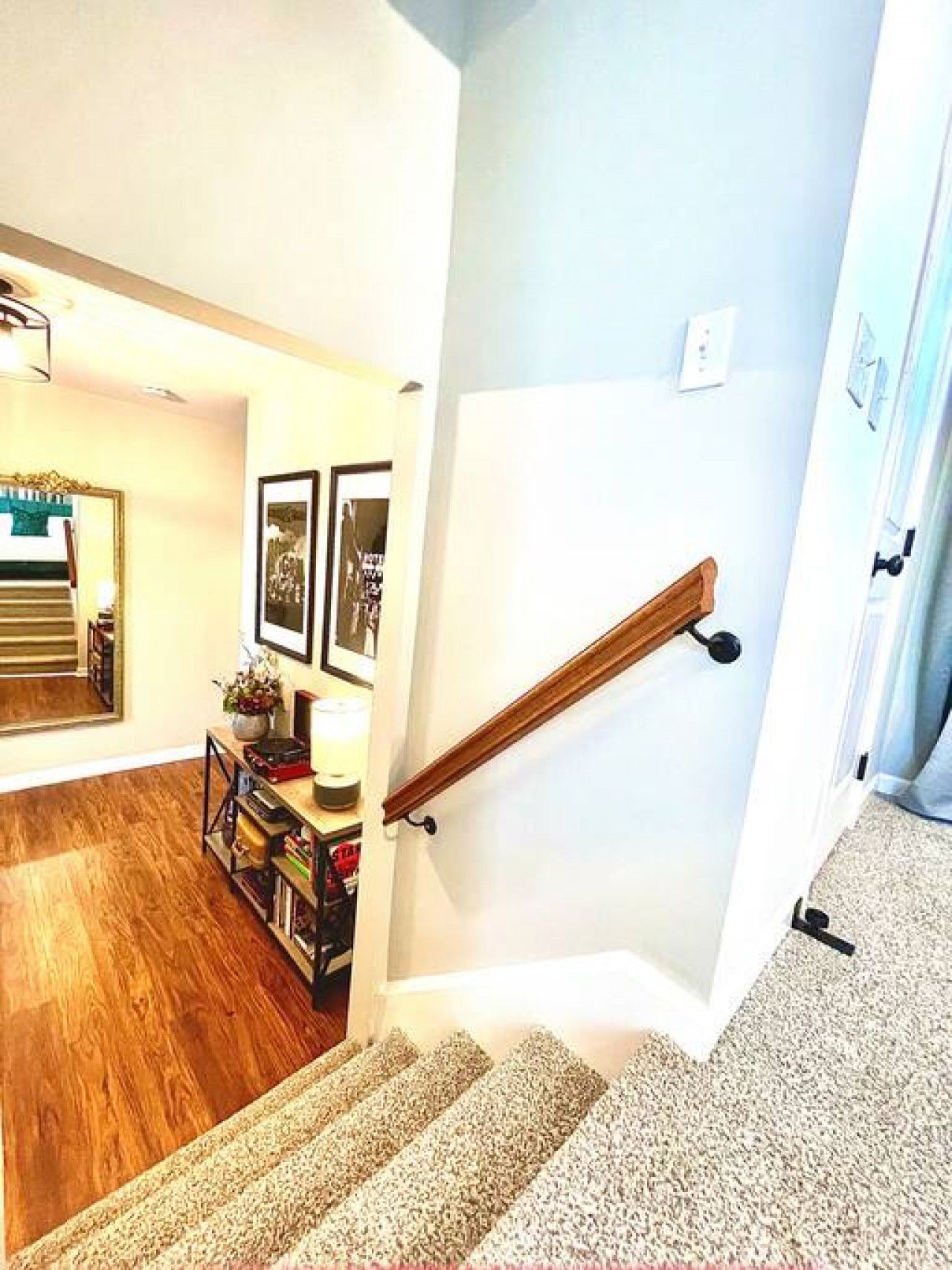Una escalera con barandilla de madera que lleva a una plataforma.