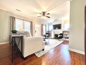 A living room with a sofa, coffee table, and a fireplace.