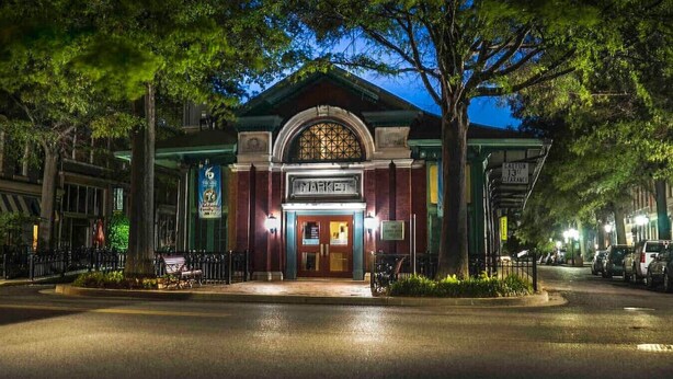 A building with a marquee sign, a gated entrance, and a street view with parked cars. - *New* Beautiful 2 Bedroom in Downtown Paducah (Paducah)