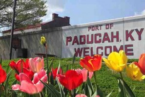 A sign with 'Port of Paducah, KY Welcome' text, surrounded by tulips.