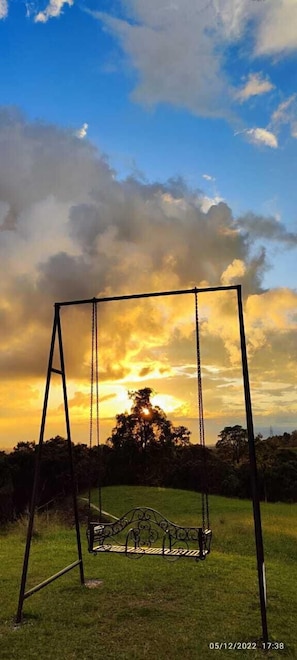A swing set in a grassy area with a sunset in the background. - Casa campestre a 15 minutos de Salento  (Salento)