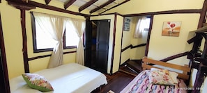 A room with a bed, a window with curtains, a door, and a staircase. - Casa campestre a 15 minutos de Salento  (Salento)