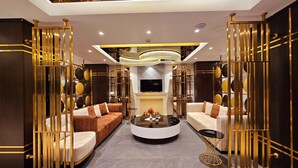 A modern living room with a central seating area, a fireplace, and a television. - Asur Imperial Hotel (Midyat)