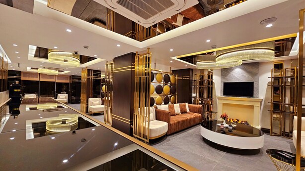 A luxurious interior with a central seating area, a flat-screen TV, and a modern fireplace. - Asur Imperial Hotel (Midyat)