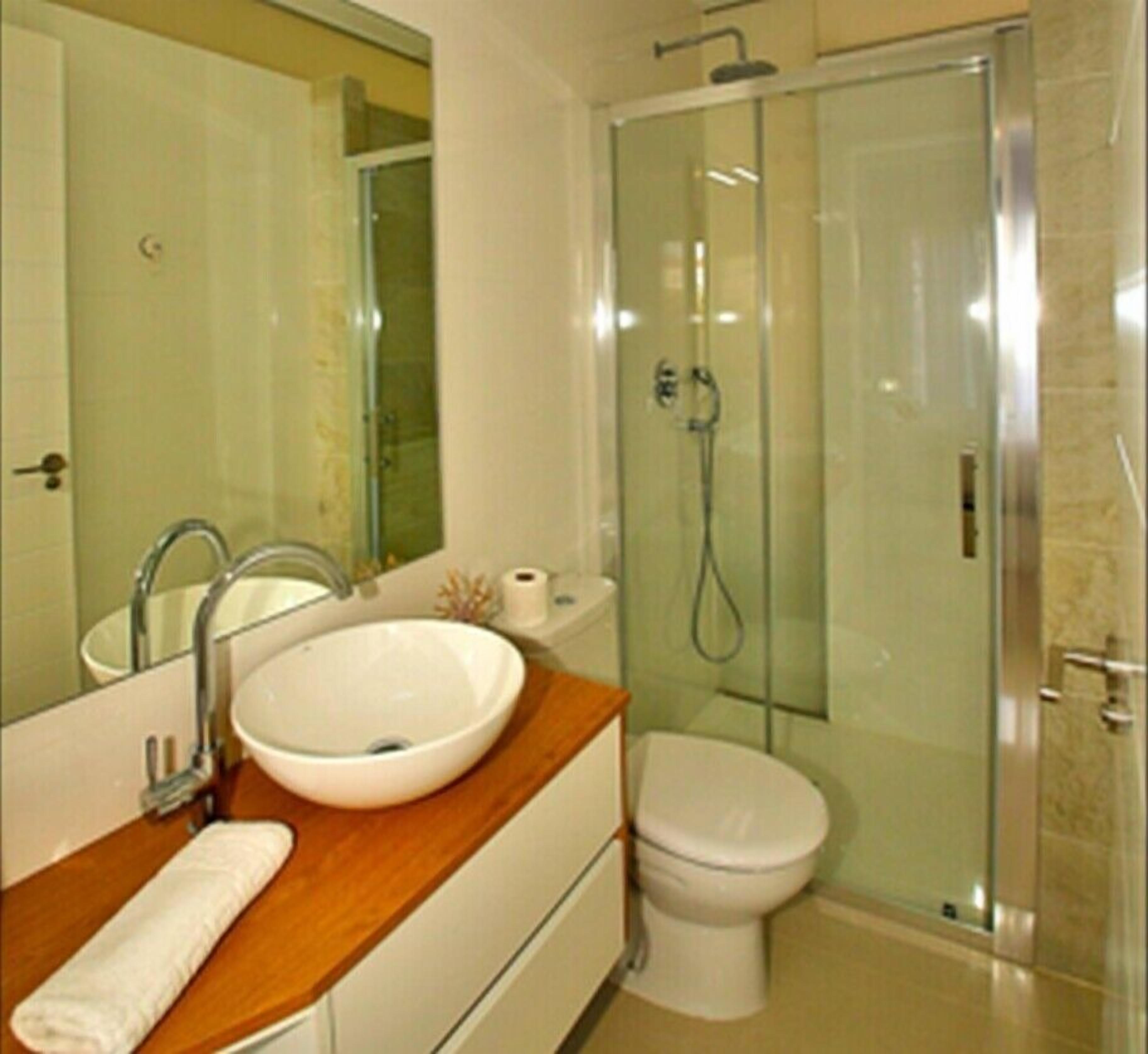 A bathroom with a sink, toilet, and glass-enclosed shower.