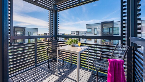 A balcony with a table, chairs, and a potted plant. - HARAKA APARTMENT WITH SUNSET BALCONY  (Tartu)