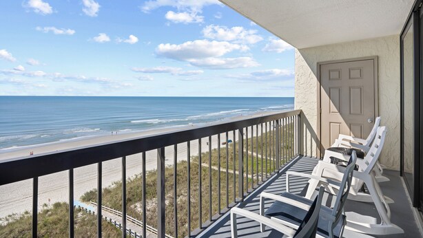 Ein Balkon mit Blick auf den Strand und das Meer.