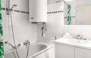 Un baño moderno con bañera, ducha y lavamanos.