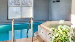 Een zwembad met een jacuzzi, een raam en een potplant.
