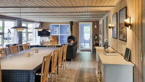 Een moderne keuken met een groot kookeiland, houten vloeren en een ingebouwde houtkachel.