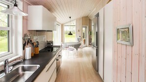 A modern kitchen with a central island, stainless steel appliances, and a view of the outdoors. - 2 bedroom awesome home in Samsø (Samsø)